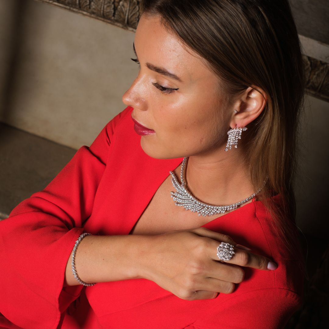A model is wearing a diamond bridal set and a red dress
