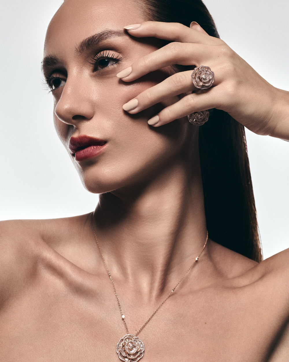 Model wearing Soit Belle Ronza rose petal diamond pendant and ring in rose gold